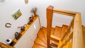 Una escalera de caracol de madera con una pared blanca y un cuadro colgado encima.