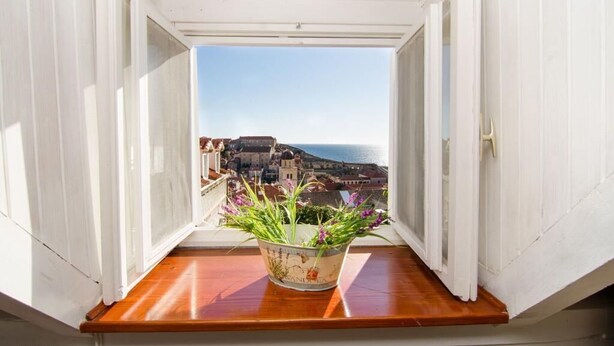 Un balcón con vistas a un pueblo costero y al mar.