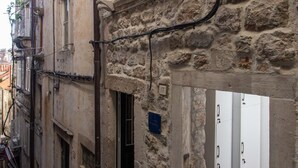 Un bâtiment étroit en pierre, doté d’une petite entrée et d’une porte qui mène à l’intérieur.