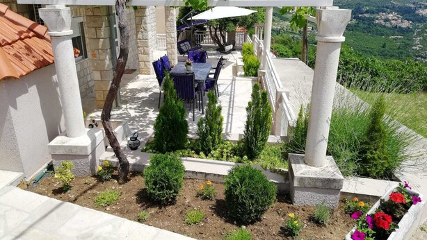 A patio with outdoor furniture, a pergola, and a view of a mountainous landscape.