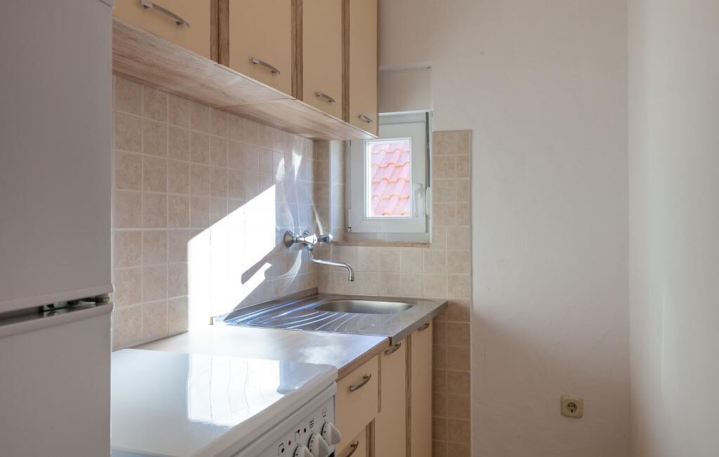 Eine Küche mit Einbauherd, Spüle und einem Fenster mit Blick zum Himmel.