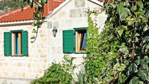 A stone building with green shutters and a visible window. - Holiday Home Harmony - Holiday Home with Terrace (Dol)
