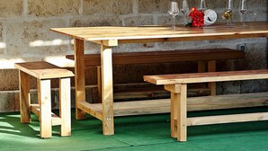 A wooden table with benches in a stone-walled room with a green floor. - Holiday Home Harmony - Holiday Home with Terrace (Dol)