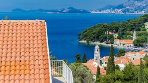A coastal town with terracotta-tiled buildings, a church, and a clear view of the sea. - Apartments & Rooms Cina - Studio Apartment with Sea View (Cavtat)