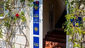 A building entrance with a blue sign reading "Apartments Blue Moon" and a sun symbol. - Apartments Rašica Molunat - One Bedroom Apartment (Molunat)