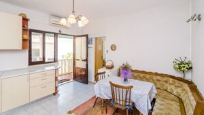 A compact living space with a kitchenette, dining area, and a sofa. - Apartments Rašica Molunat - One Bedroom Apartment (Molunat)