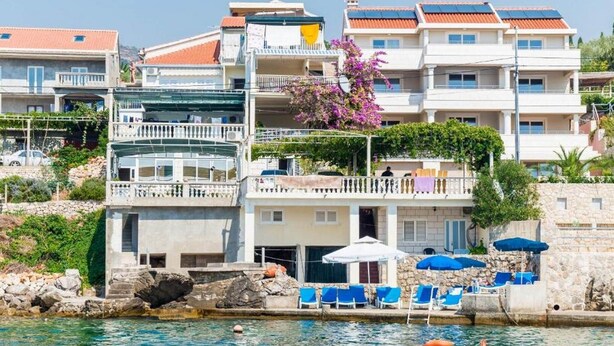 A coastal hotel with multiple balconies, a pool area with sun loungers, and a clear view of the sea. - Apartments Rašica Molunat - One Bedroom Apartment (Molunat)