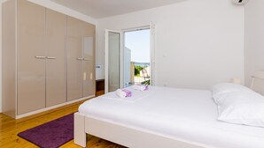 Une chambre à coucher avec un lit, une armoire et un balcon.