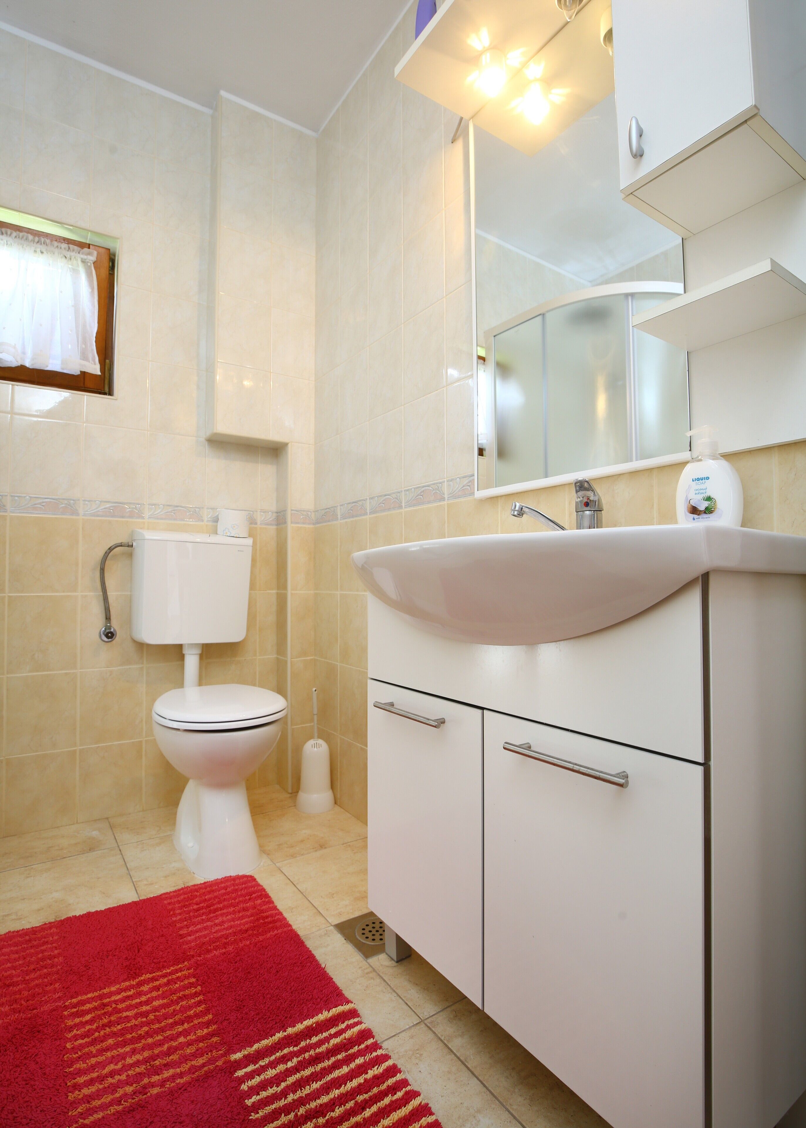 Ein Badezimmer mit Toilette, Waschbecken und Spiegel.
