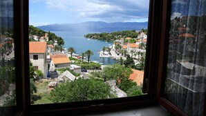 A coastal town with buildings, boats, and mountains in the background. - Apartments Boro - Two Bedroom Apartment with Sea View (A2) (Splitska)