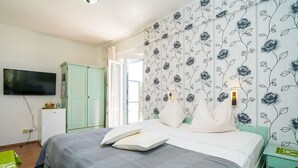 Ein Schlafzimmer mit einem Bett, einem Fernseher, einem Kleiderschrank und einem Nachttisch.