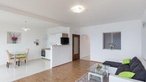 Un apartamento moderno con comedor, kitchenette y sala de estar.