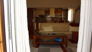 A living room with a sofa, coffee table, and a kitchen in the background. - Apartments Sweet Life - Three-Bedroom Apartment with Terrace and Sea view (Renata) (ST) (Supetar)