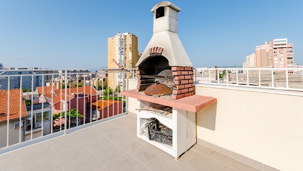 A rooftop with a brick-built oven, a white railing, and a clear view of the cityscape. - Apartment Marko (ST) - Three Bedroom Apartment with Balcony and Garden View (Split)