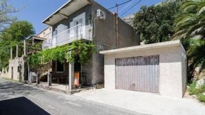 A two-story house with a balcony and a garage. - Apartments Felix Mljet - Studio with Balcony (Felix) (Babino Polje)