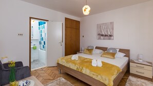 Un dormitorio con una cama de madera, una mesita de noche y una lámpara colgante.
