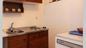 Uma cozinha compacta com armários de madeira, pia e lava-louças.