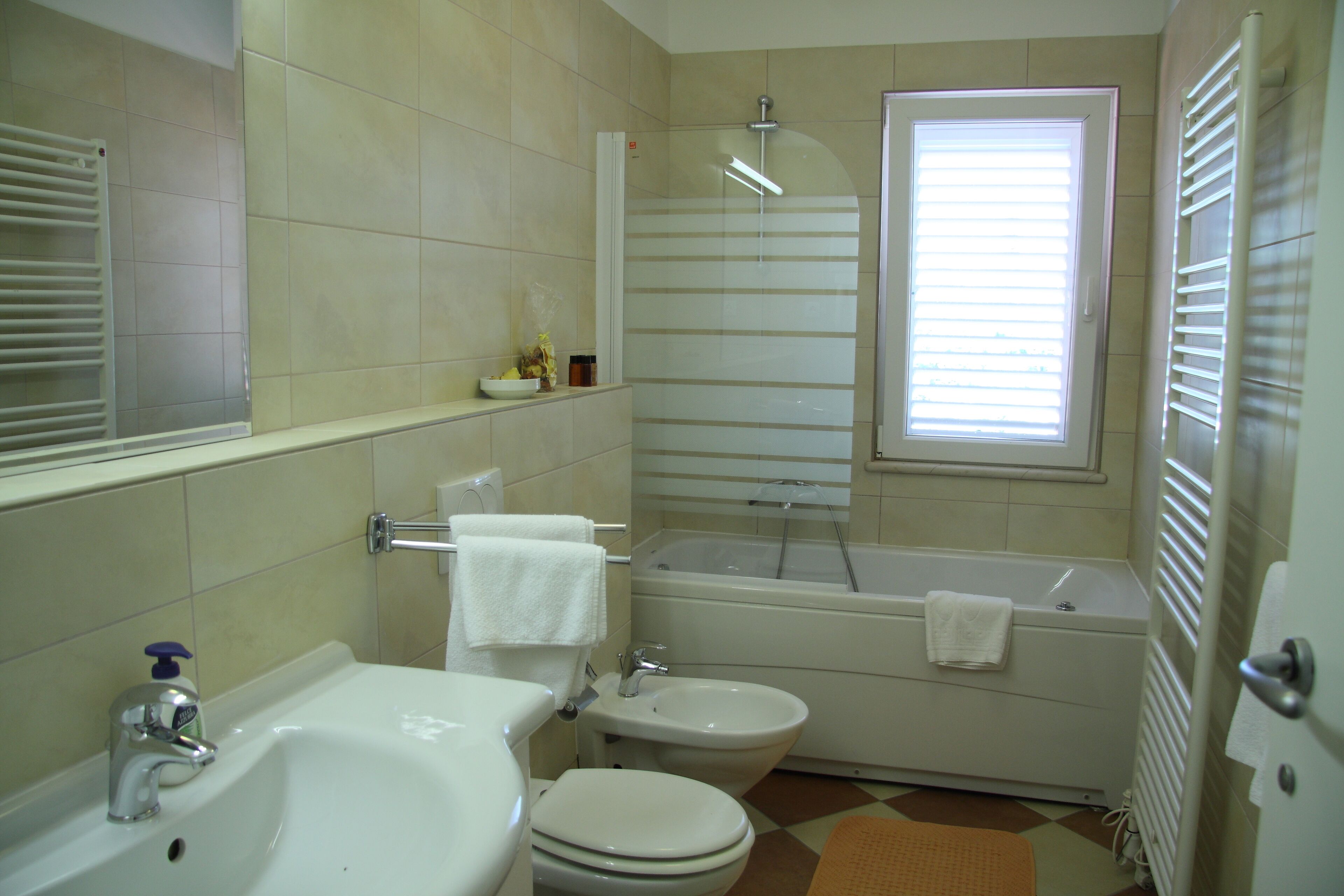 Et badeværelse med vask, toilet, bidet og badekar.
