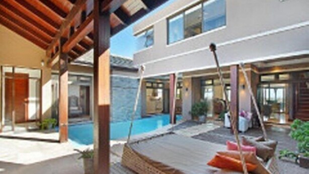 A modern hotel with a pool, outdoor seating area, and a covered patio. - Luxury Vacation Villa (Cape Town)