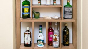 A wooden liquor cabinet with various bottles of alcohol, including vodka, gin, and whiskey. - Guest House Fontana - Two Bedroom Apartment with Balcony and Sea View (Mlini)