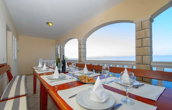 Mesa con platos, vasos y una botella, con vistas a un paisaje pintoresco.