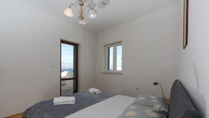 A bedroom with a bed, a window, and a ceiling light. - Apartment Perina - Two Bedroom Apartment with Terrace and Sea View (Sutivan)