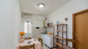 Une petite cuisine comprenant une table à manger, des chaises, un évier et un placard.