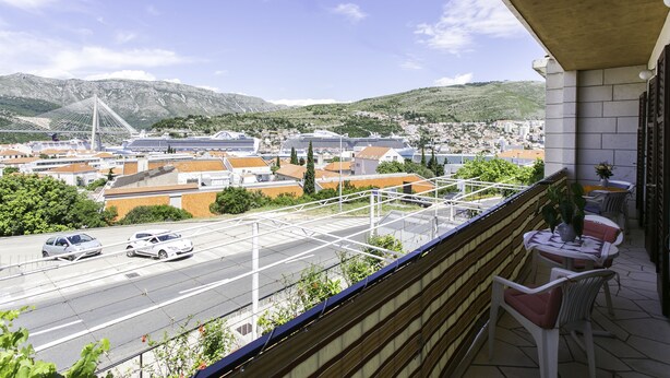 Un balcon donnant sur un paysage urbain, avec une vue sur un pont et des bâtiments.