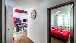 Ein modernes Hotelzimmer mit einem großen Bett, einem Essbereich und einer Küche im Hintergrund.