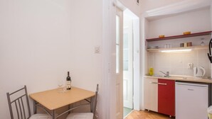 A compact kitchen with a dining area, a refrigerator, and a dishwasher. - Villa Iveta - Twin Room (Ground Floor) - Martina (Dubrovnik)