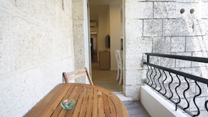 Une table en bois avec un verre dessus, une chaise et une rambarde en métal.