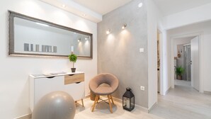 A modern interior with a large mirror, a grey wall, a wooden floor, a grey exercise ball, a cushioned chair, and a lantern. - Holiday Home Diana - Comfort Two Bedroom Apartment with Terrace and Sea View (Vela Luka)