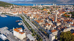 A coastal cityscape with a marina, historic buildings, and a prominent church. - Old City Center Suite - One Bedroom Suite (Split)