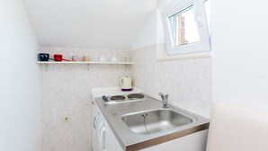 A compact kitchenette with a stove, sink, and a window. - Apartments Mali Paradiso - Studio Apartment with Pool View (Mlini)