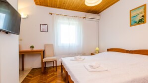 A bedroom with a wooden bed, a desk, a chair, and a TV. - Apartments Mali Paradiso - Studio Apartment with Pool View (Mlini)