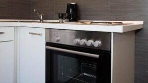 A modern kitchen with a built-in oven, a coffee maker, and a range hood.