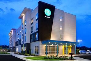 A modern hotel building with a prominent 'tru by Hilton' sign, multiple floors, and a well-lit entrance. - Tru By Hilton Columbia Greystone (Columbia)