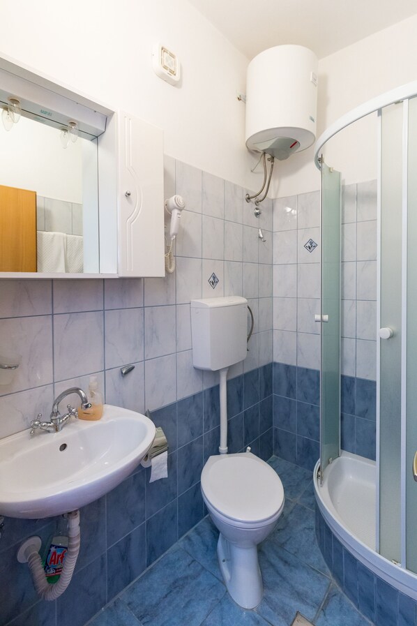 A bathroom with a sink, toilet, and shower.