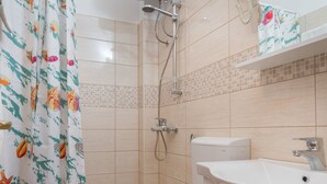 Un baño con ducha, inodoro y lavabo.