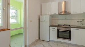 A kitchen with white cabinets, a built-in oven, and a stainless steel range hood.