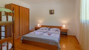 A bedroom with a wooden bed, a wardrobe, and two bedside tables with lamps.