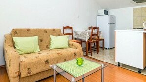 A small, furnished room with a sofa, a dining table with chairs, a refrigerator, and a microwave. - Guest House Fontana - Superior Studio with Sea View (2 Adults) (Mlini)