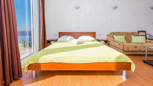 A hotel room with a bed, a sofa, and a window with curtains. - Guest House Fontana - Superior Studio with Sea View (2 Adults) (Mlini)