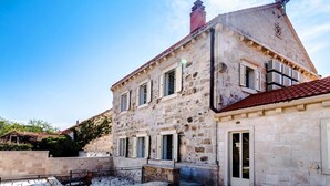 A stone building with a red-tiled roof, multiple windows, and a satellite dish. - Rooms Miron -  Superior Double or Twin Room with Sea View (Sumartin)