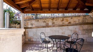 An outdoor patio with stone walls, a wooden ceiling, and metal chairs. - Rooms Miron -  Superior Double or Twin Room with Sea View (Sumartin)