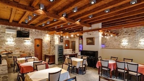 A restaurant with stone walls, wooden beams, and tables set for dining. - Rooms Miron -  Superior Double or Twin Room with Sea View (Sumartin)