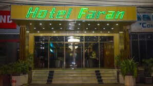 The entrance to Hotel Faran with a neon sign, glass doors, and potted plants. - Hotel Faran (Karachi)