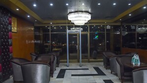 A hotel lobby with a chandelier, seating area, and a glass door entrance. - Hotel Faran (Karachi)