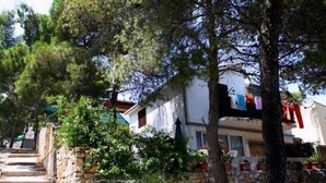 Una escalera de piedra que lleva a un edificio blanco con balcón.