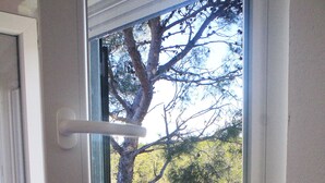 Una habitación con ventana que da a una vista arbolada.